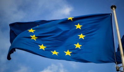 Documenti normativi europei impilati su una scrivania